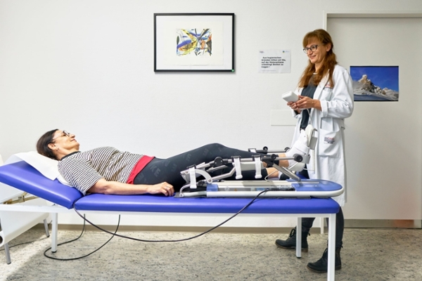 Frau auf Liege mit Motorschiene am Bein Frau auf Liege mit Motorschiene am Bein