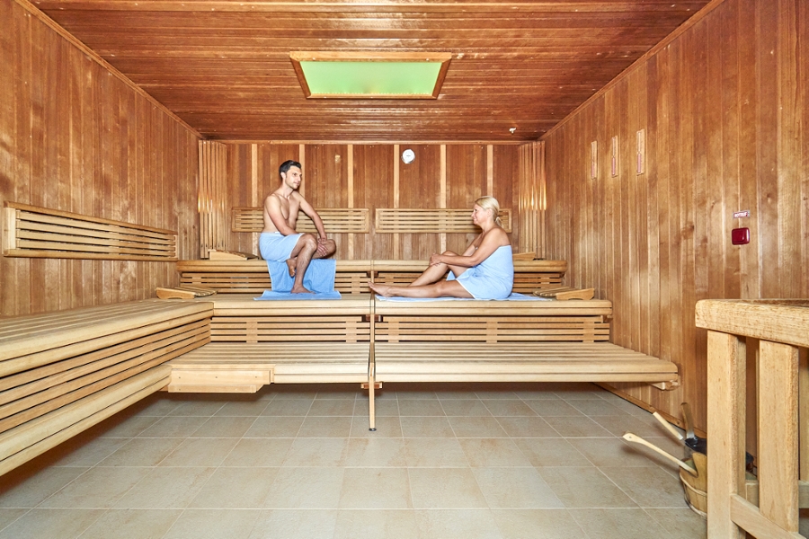 Zwei sitzende Rehabilitanden in einer großen Sauna mit Oberlicht