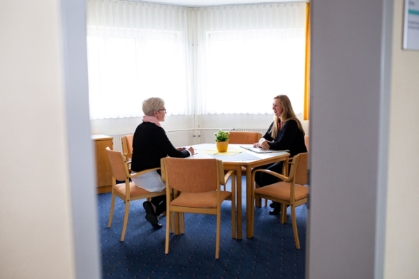 Sozialarbeiterin und Rehabilitandin im Gespräch am Tisch Sozialarbeiterin und Rehabilitandin im Gespräch am Tisch